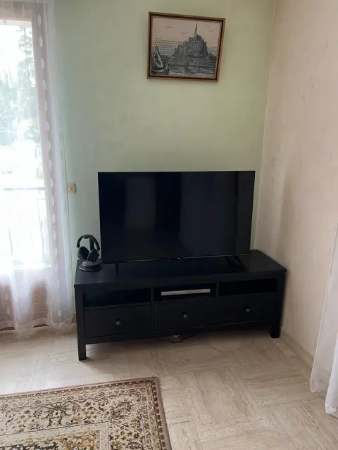Le coin salon avec la télévision sur son meuble bas et la cheminée électrique, commandée à la télécommande.