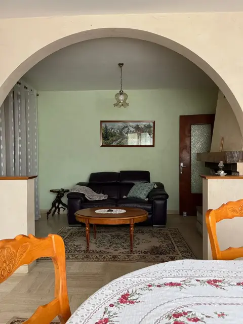 Le salon et sa table basse, ouvert sur la salle à manger par une large arche.