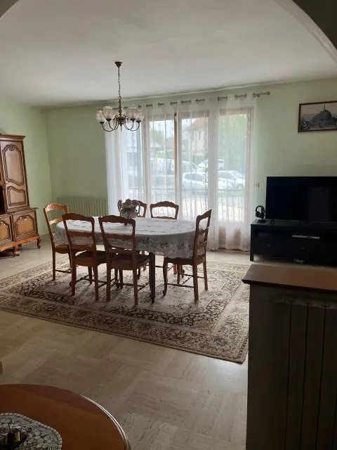 La salle à manger et sa baie vitrée donnant sur le balcon et le jardin.