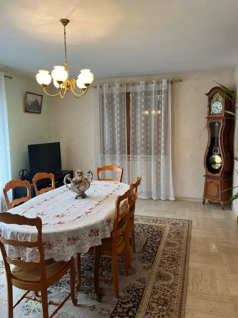 La table dressée dans la salle à manger, à côté de l'horloge comtoise.