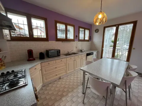 La table de la cuisine et ses chaises, sous la fenêtre donnant sur le jardin.