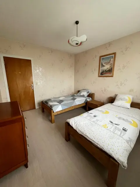 La chambre twin vue depuis la porte, deux lits simples de part et d'autre de la fenêtre.